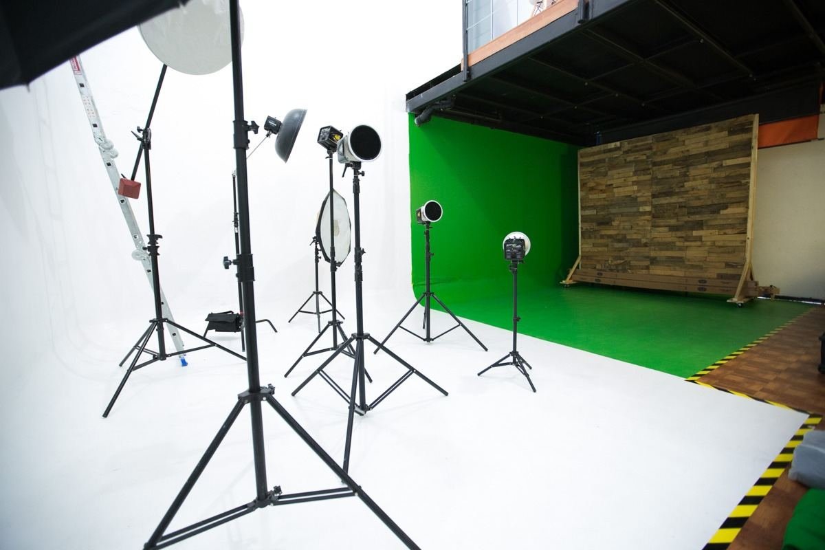 Infinito blanco y pared chroma verde del estudio fotográfico con luces y muro de madera