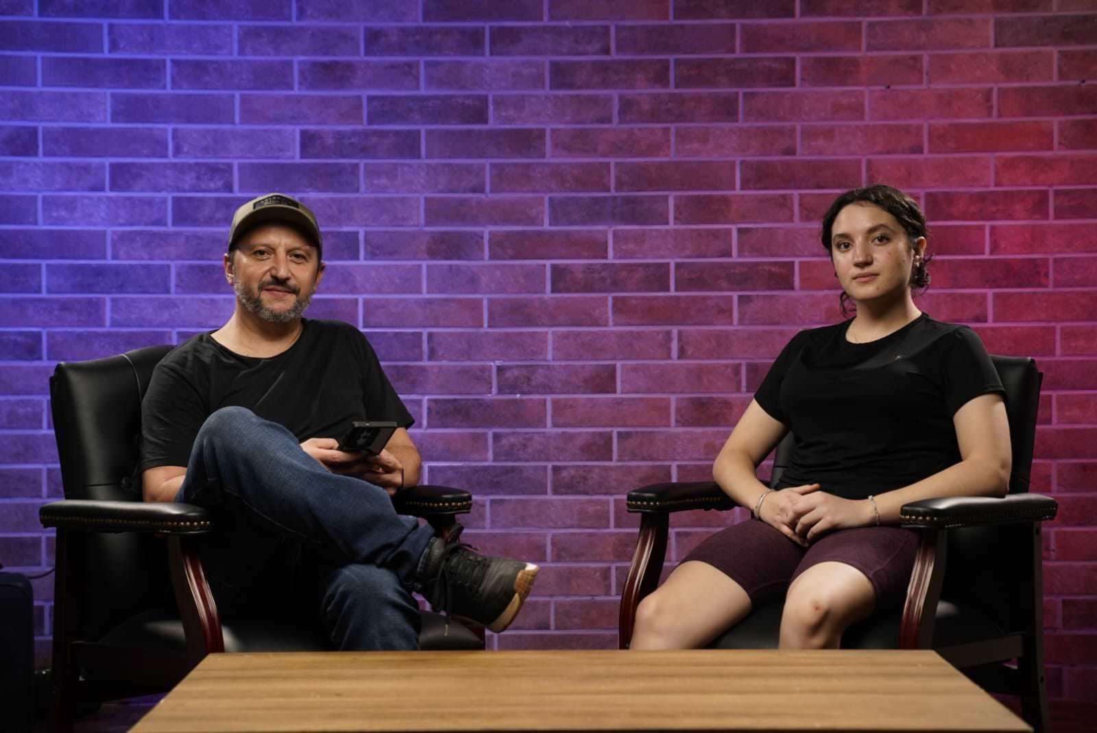 Set de entrevista con muro de ladrillo e iluminación de color